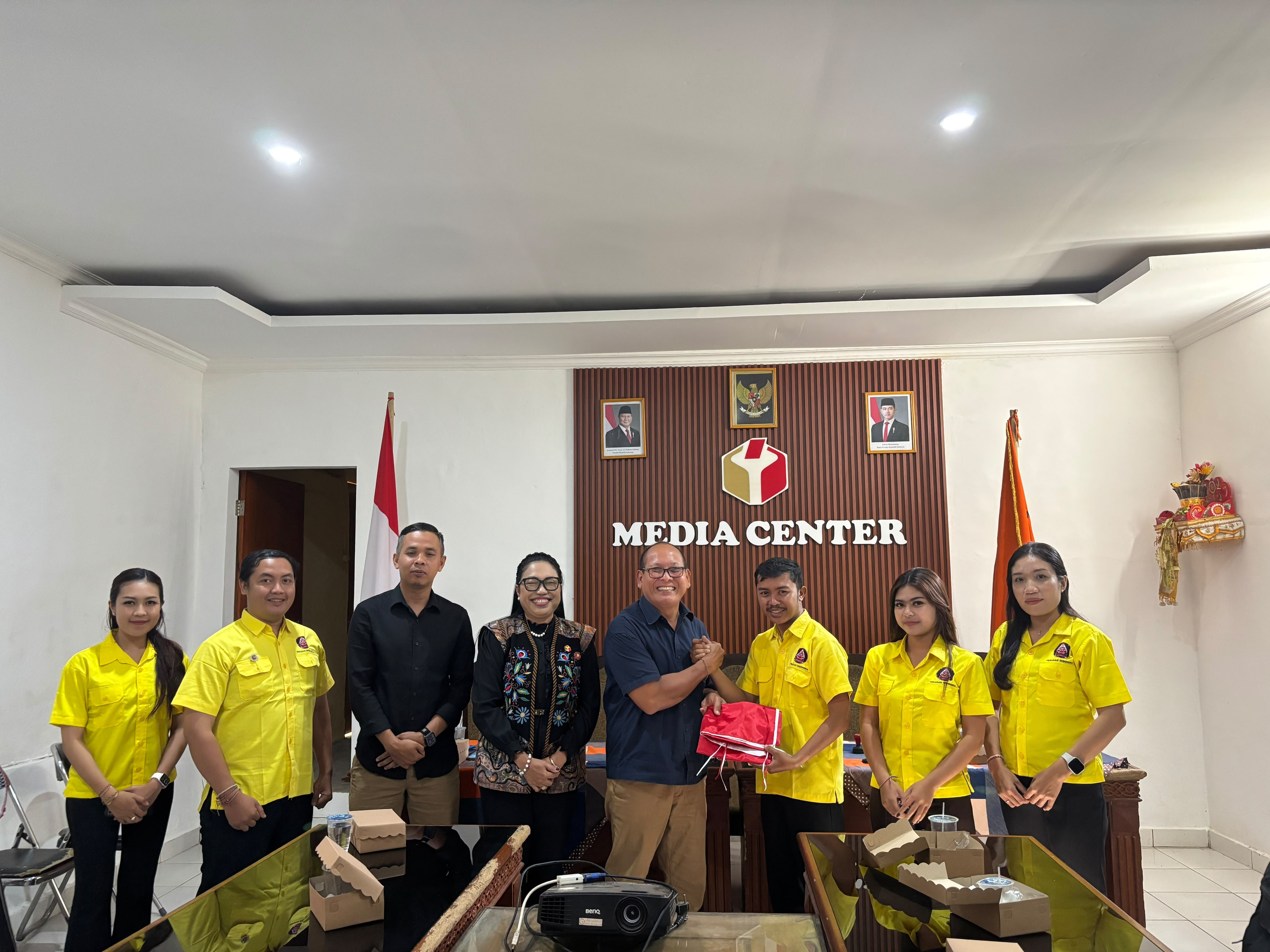 Pimpinan Bawaslu Karangasem menyerahkan bendera kepada Peradah Karangasem usai penandatanganan PKS