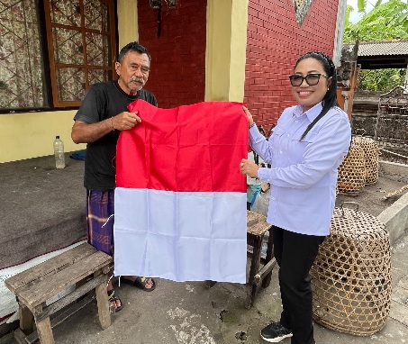 Diana Devi memberikan bendera kepada Masyarakat sekitar kantor Bawaslu Karangasem 